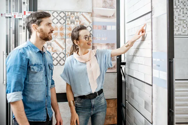 A woman showing tiles used for bathroom to a man