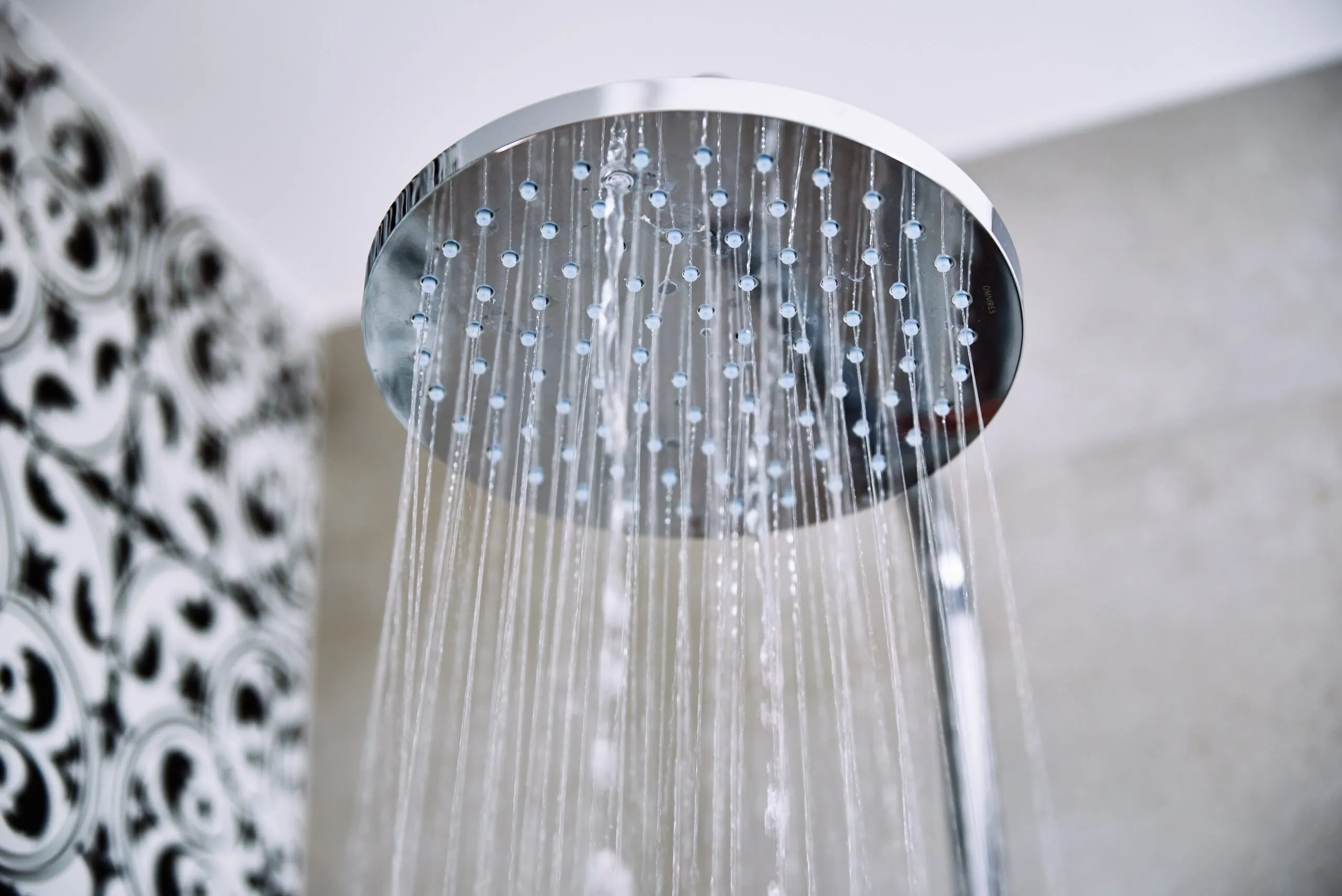 Water-flowing-from=shower-head-in-bathroom-awdns