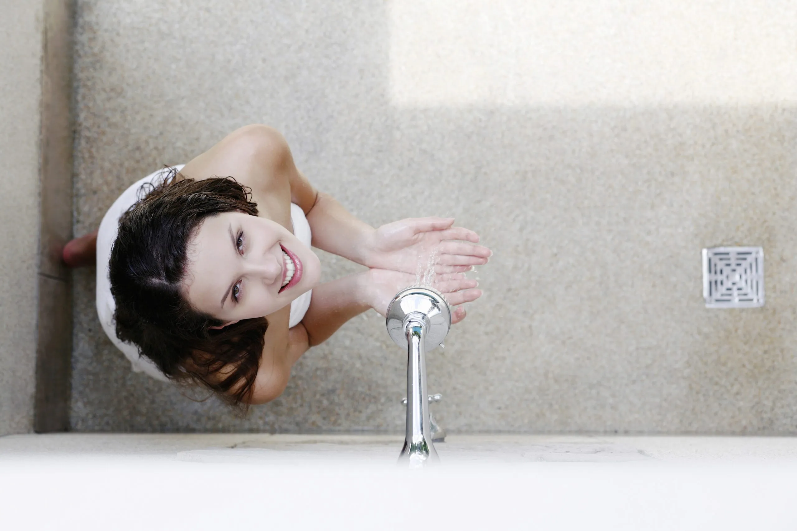 A woman having a hot shower in the bathroom